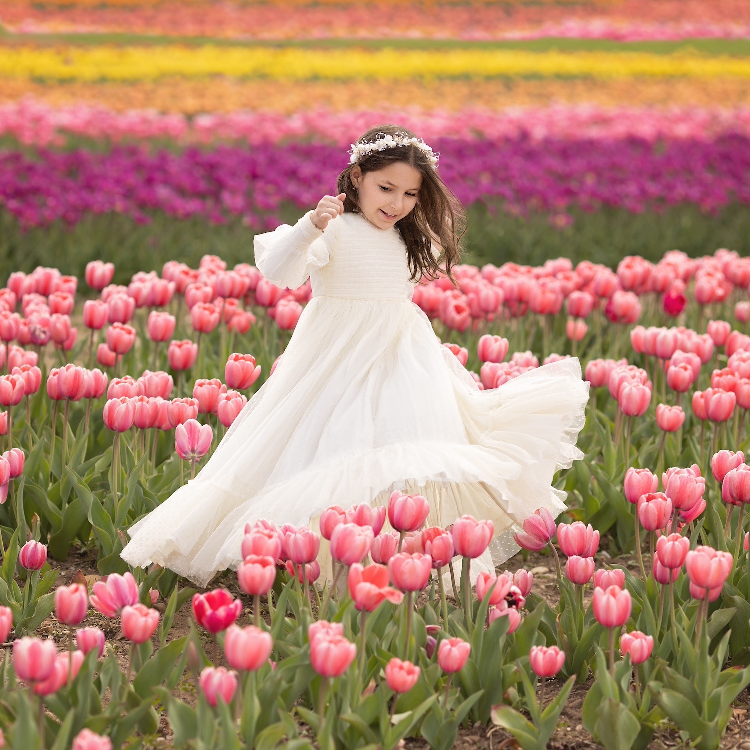 a girl twirling in a white dress at a tulip farm