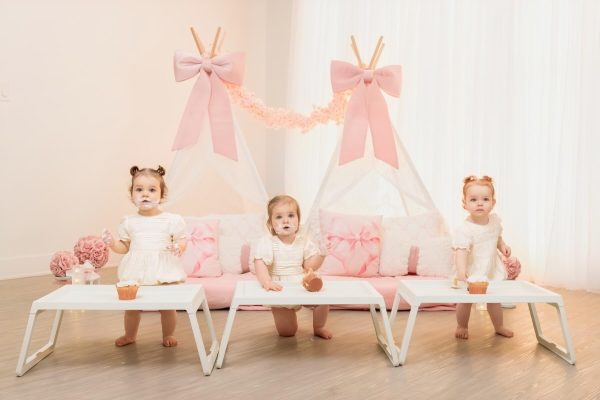 3 adorable one year olds enjoying cupcakes during a slumber party themed studio session