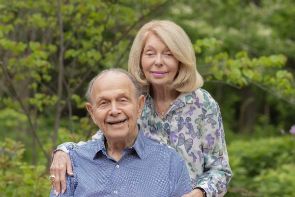 95 year old grandfather and his wife posing in a garden