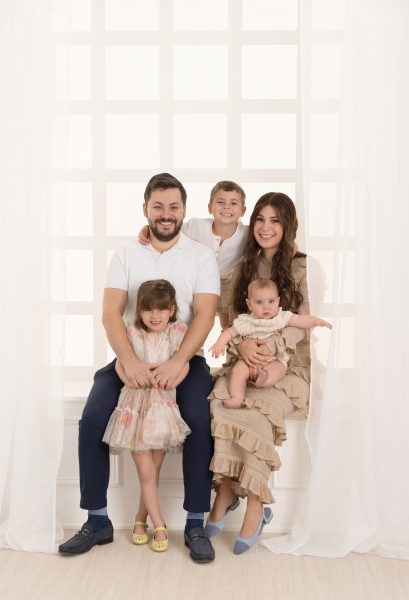family posed in a white window in a Chicago studio