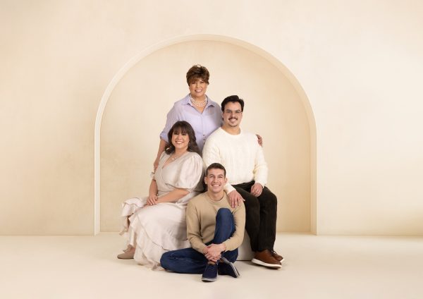 mother with her adult children on a cream arched backdrop in a Chicago studio