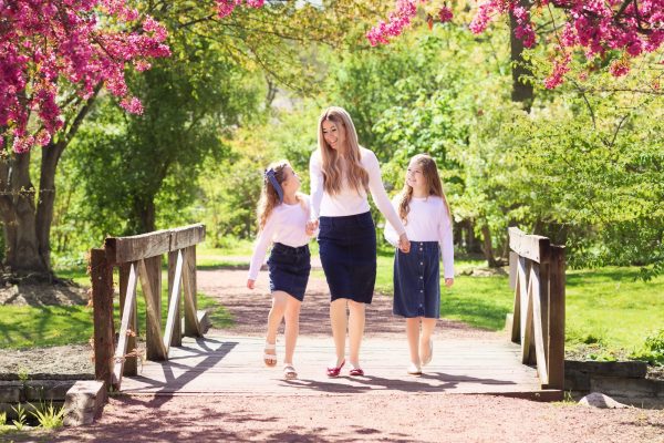 mom and daughters walking over a bridge in a chicago park