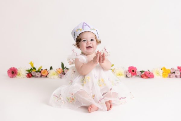 one year old girl at her floral cake smash