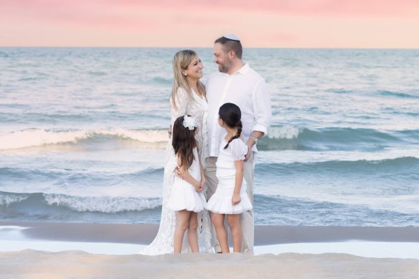 family smiling at a beach sunset session
