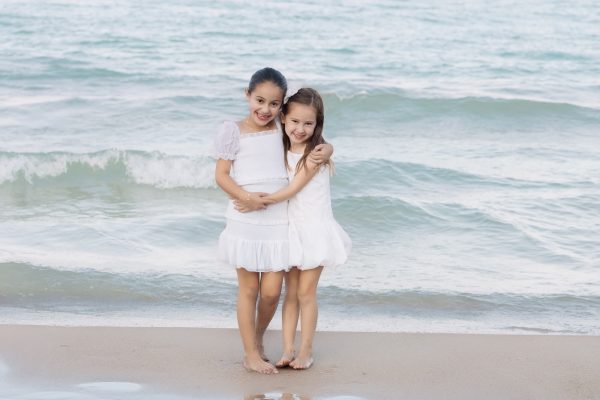 sisters hugging in each on the beach
