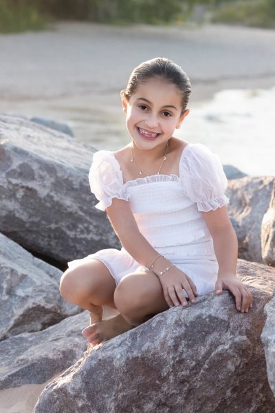 girl sitting on the rocks at the beach
