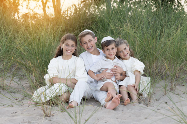 Siblings smiling at the camera during a beach session at Gillson Beach