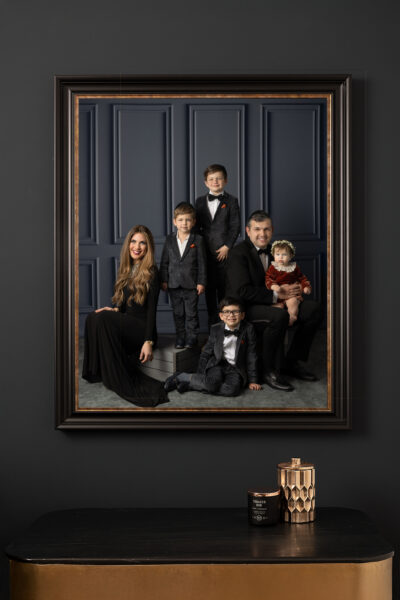 mock up of an elegant family portrait framed in a black and gold frame in their Chicago home