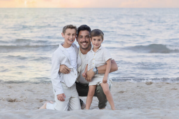 Father and sons posing together on the shore of Lake Michigan in Wilmette