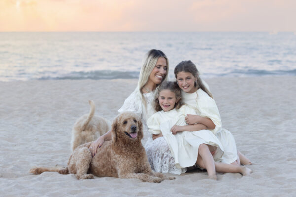 Mother, daughters and dogs posing together on the shore of Lake Michigan in Wilmette