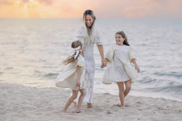 mother and daughters dancing together on the shore of Lake Michigan in Wilmette
